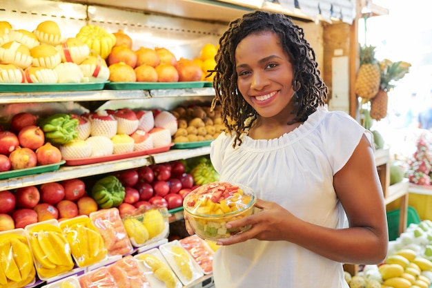 Jolie femme avec bol de salade de fruits