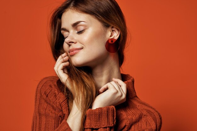 Jolie femme boucles d'oreilles rouges bijoux cosmétiques posant