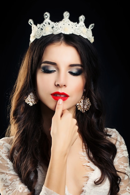 Jolie femme brune aux cheveux bouclés et maquillage des lèvres rouges
