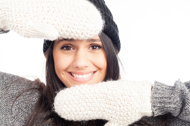 Jolie femme brune avec un bonnet en laine un pull et des gants souriants et gais
