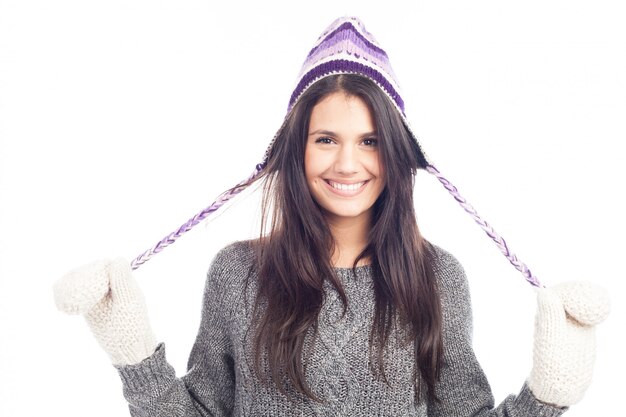 Jolie femme brune avec un bonnet péruvien en laine un pull et des gants souriants et gais