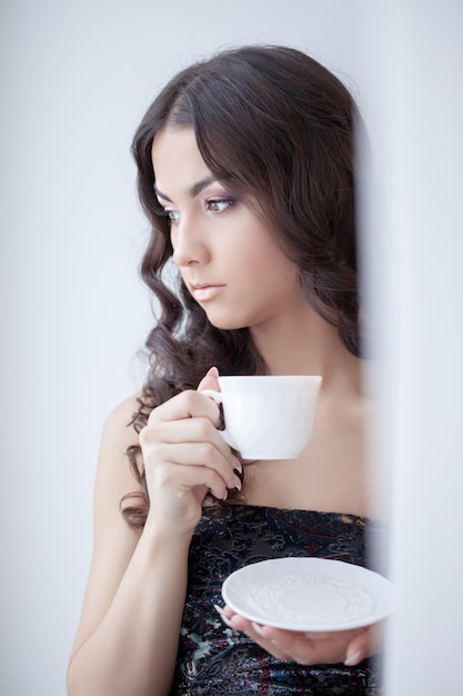 Jolie femme brune buvant du café