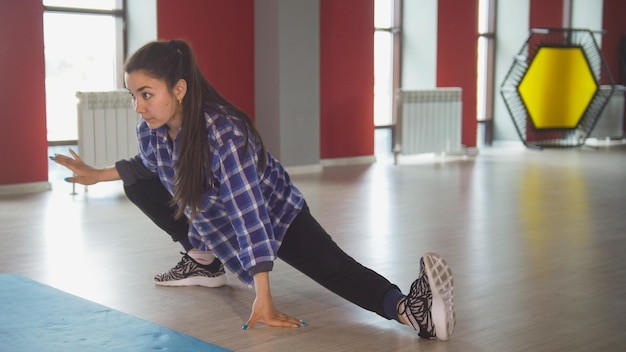 Photo jolie femme brune qui s'étend dans la salle de fitness se bouchent