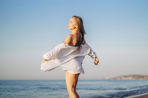 Jolie femme brune se détendre sur la plage au bord de la mer.