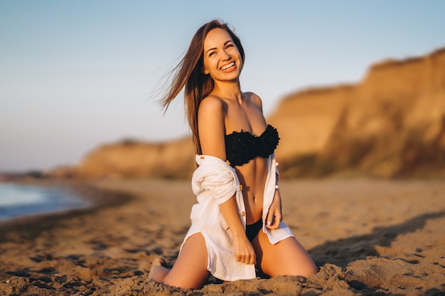 Jolie femme brune se détendre sur la plage à la mer.