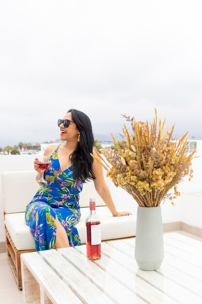 Jolie femme buvant du vin sur une terrasse