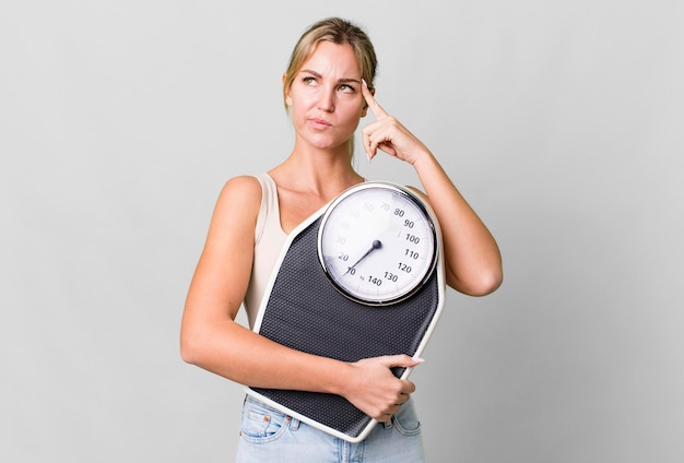 Jolie femme caucasienne avec un concept de régime et de remise en forme d'échelle de poids