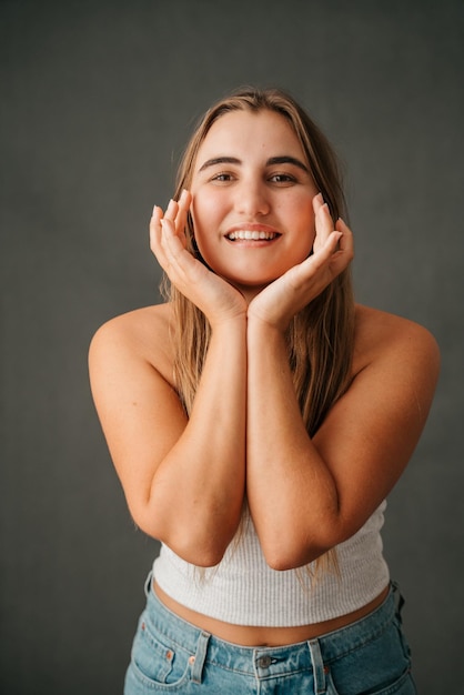 Jolie femme caucasienne encadrant son visage avec ses mains