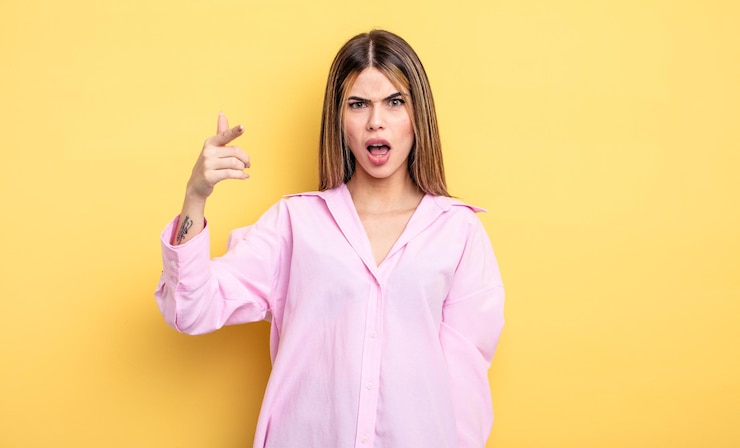 Photo jolie femme caucasienne pointant vers la caméra avec une expression agressive en colère ressemblant à un patron furieux et fou