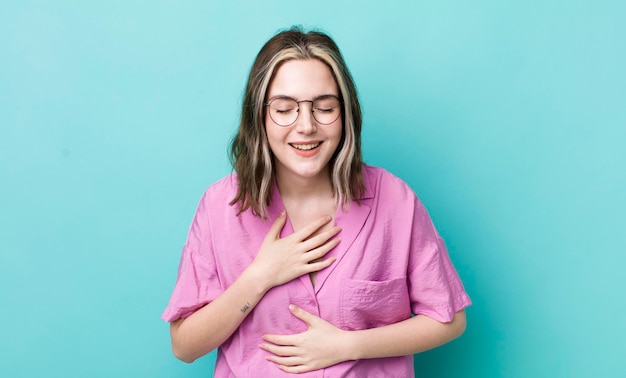 Jolie femme caucasienne riant à haute voix à une blague hilarante se sentant heureuse et joyeuse s'amusant