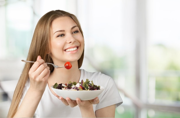 Jolie femme caucasienne avec salade sur fond