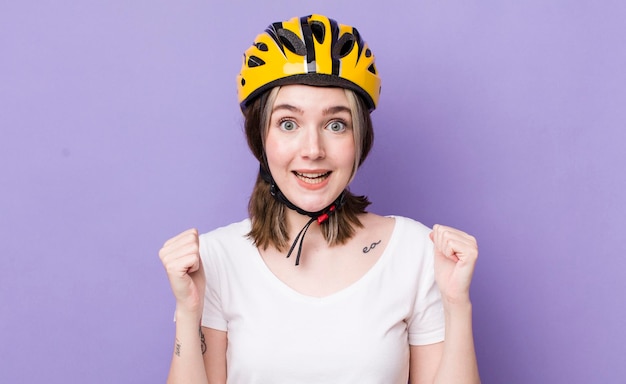 Jolie femme caucasienne se sentant choquée en riant et célébrant le concept de vélo de succès