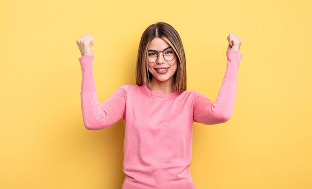 Jolie femme caucasienne se sentant heureuse, positive et réussie, célébrant la victoire, les réalisations ou la bonne chance