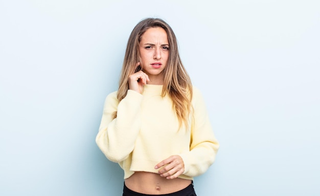 Jolie femme caucasienne se sentant stressée, frustrée et fatiguée, frottant le cou douloureux avec un regard inquiet et troublé