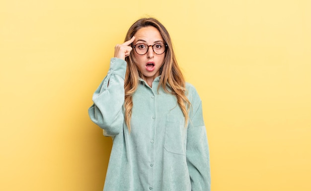 Jolie femme caucasienne semblant surprise, bouche bée, choquée, réalisant une nouvelle pensée, idée ou concept