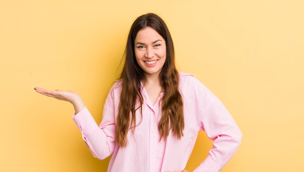 Jolie femme caucasienne souriante, confiante, réussie et heureuse, montrant un concept ou une idée sur l'espace de copie sur le côté