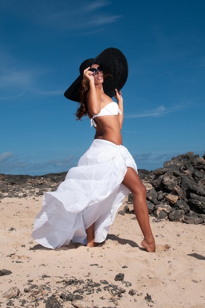 jolie femme avec chapeau dans une zone côtière et plage par beau temps