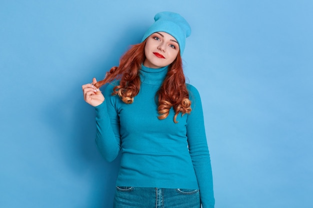 Jolie femme charmante aux cheveux rouges robes pull et bonnet