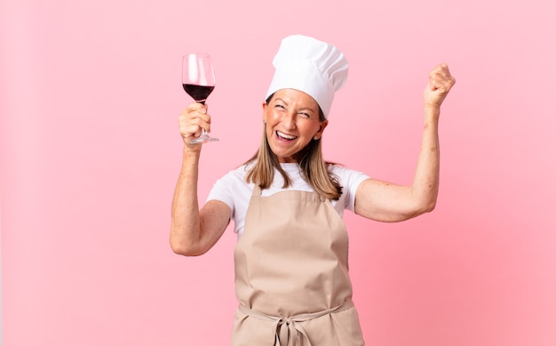 Jolie femme de chef d'âge moyen avec un verre de vin