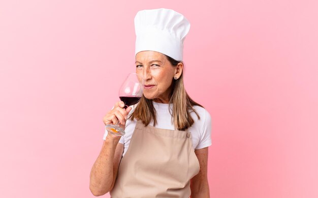 Jolie femme de chef d'âge moyen avec un verre de vin