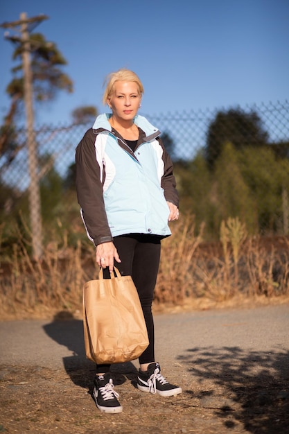 Jolie femme sur un chemin tenant un sac