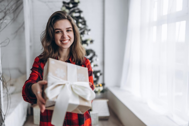 Jolie femme en chemise et chaussettes tenant un cadeau