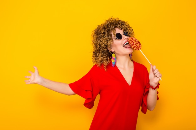 Jolie femme avec des cheveux courts et bouclés avec des bonbons