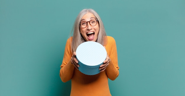 Jolie femme cheveux gris avec une boîte cadeau