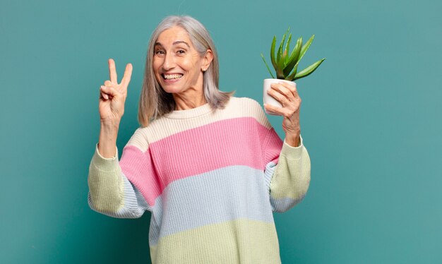 Jolie femme cheveux gris avec un cactus