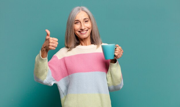 Jolie femme cheveux gris avec un café ou un thé