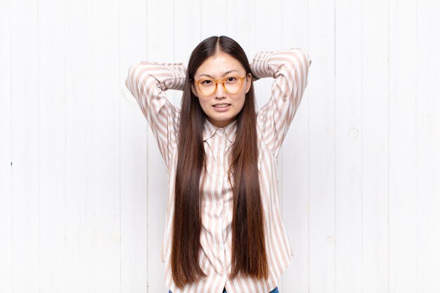 Jolie femme chinoise contre un mur blanc