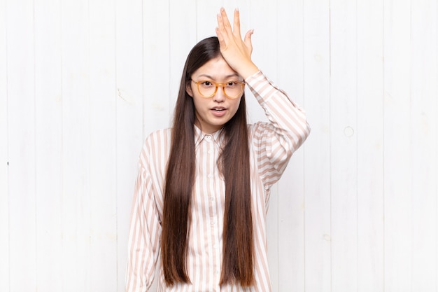 Jolie femme chinoise contre un mur blanc