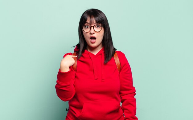 Jolie femme à la choqué et surpris avec la bouche grande ouverte, pointant vers soi