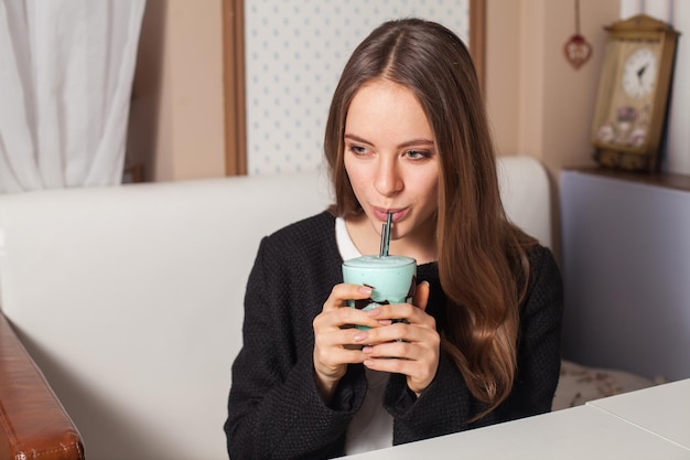 Jolie femme avec cocktail dans un café moderne