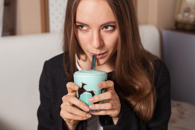 Jolie femme avec cocktail dans un café moderne