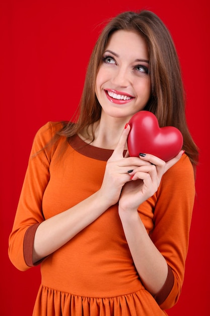 Jolie femme avec coeur, sur fond rouge