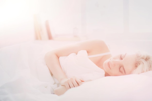 Jolie femme couchée sur son lit à la maison