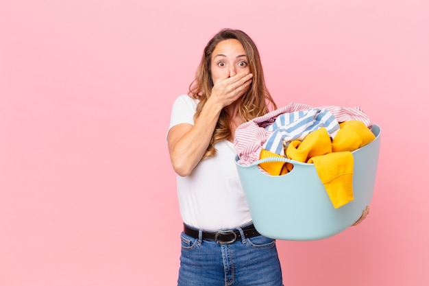 Jolie femme couvrant la bouche avec les mains avec un linge choqué et lavant.