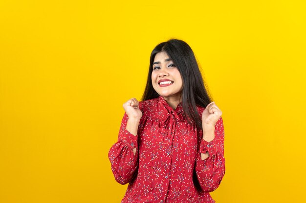 Jolie femme curieuse avec une expression heureuse isolée sur fond jaune