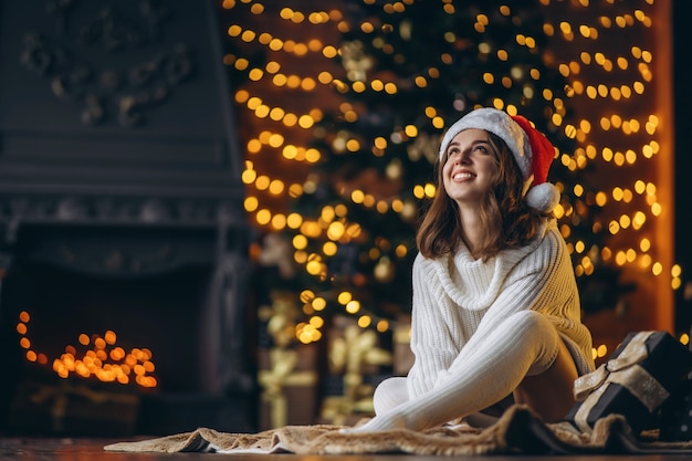 Jolie femme dans un pull chaud, des chaussettes et un chapeau de Noël