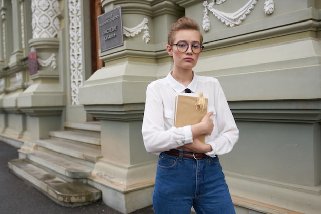 Jolie femme dans la rue près du bâtiment reste éducation