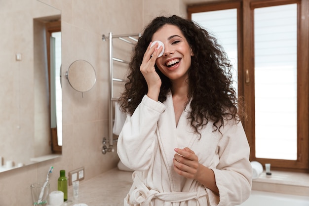 Jolie femme dans la salle de bain prend soin de sa peau.