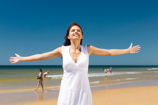 Jolie femme debout au soleil sur la plage