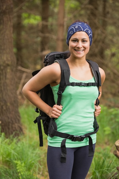 Jolie femme debout dans une forêt en randonnée