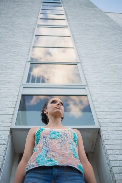 Jolie femme debout devant un grand bâtiment