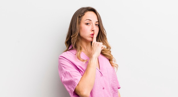 Jolie femme demandant le silence et le silence en faisant des gestes avec le doigt devant la bouche en disant chut ou en gardant un secret