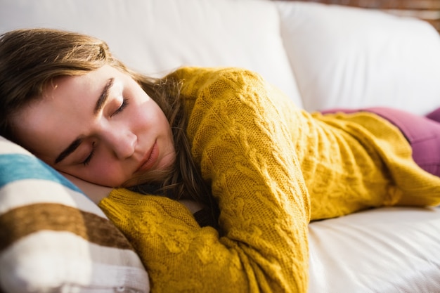 Jolie femme dormant sur le canapé dans le salon