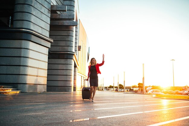 Jolie femme élégante appelant un taxi à l'aéroport