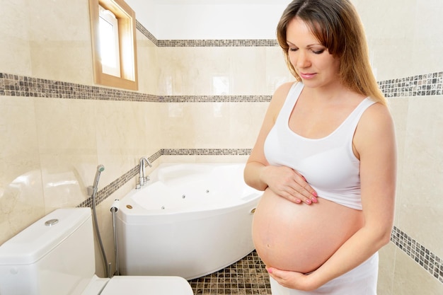 Une jolie femme enceinte dans la salle de bain