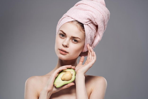 Jolie femme épaules nues avocat en main traitements de spa de fruits exotiques